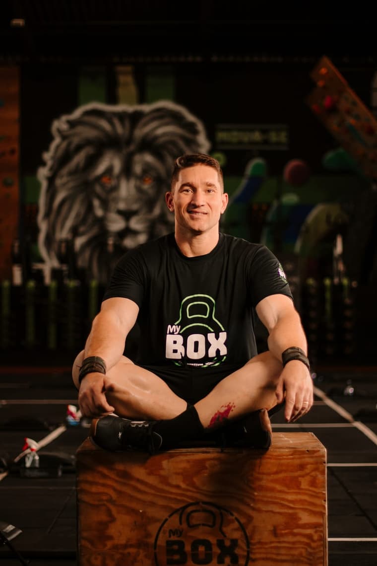 Área de treino de uma unidade My Box, com rig de Cross Training, kettlebells e o mural do leão da marca ao fundo